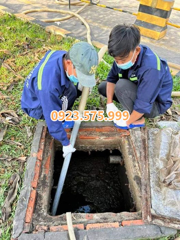 nhân viên Kiến Môi Trường mặc đồng phục hút hầm cầu quận 12